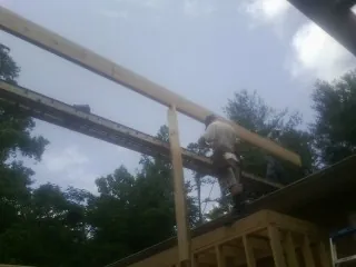 Carpenter setting a ridge beam over a new addition frame — Ice Dam Removal by Roofing Brothers in Charlotte Court House
