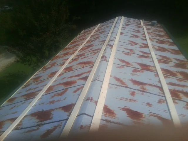 Rusted metal roof panels with new wood purlins before replacement — Storm Damage Roof Repair in Charlotte Court House by Roofing Brothers