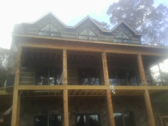 Dormers and porch framing on a large log home under construction — Roof Coating work by our crew in Charlotte Court House