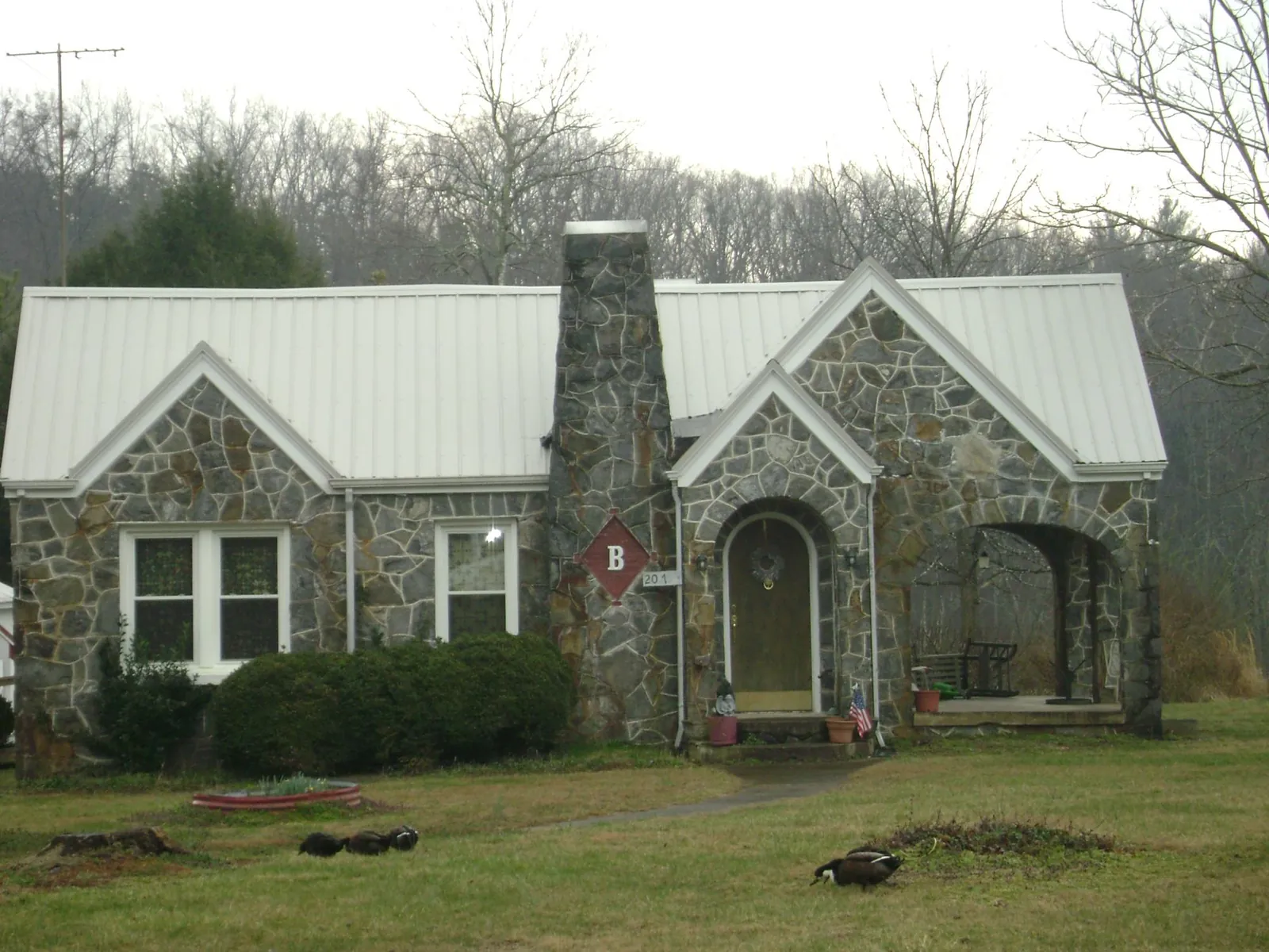 White metal roof on a stone cottage with steep gables in Charlotte Court House