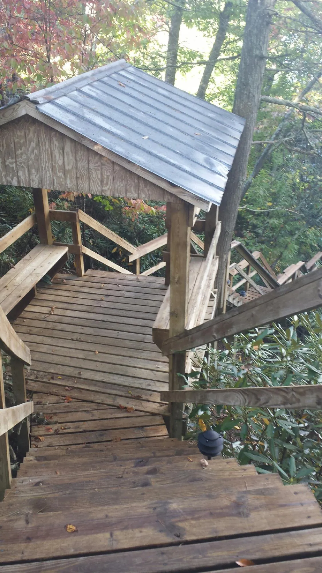 Metal roofed shelter over wooden steps on a wooded walkway — Skylight Repair & Installation work by our crew in Charlotte Court House