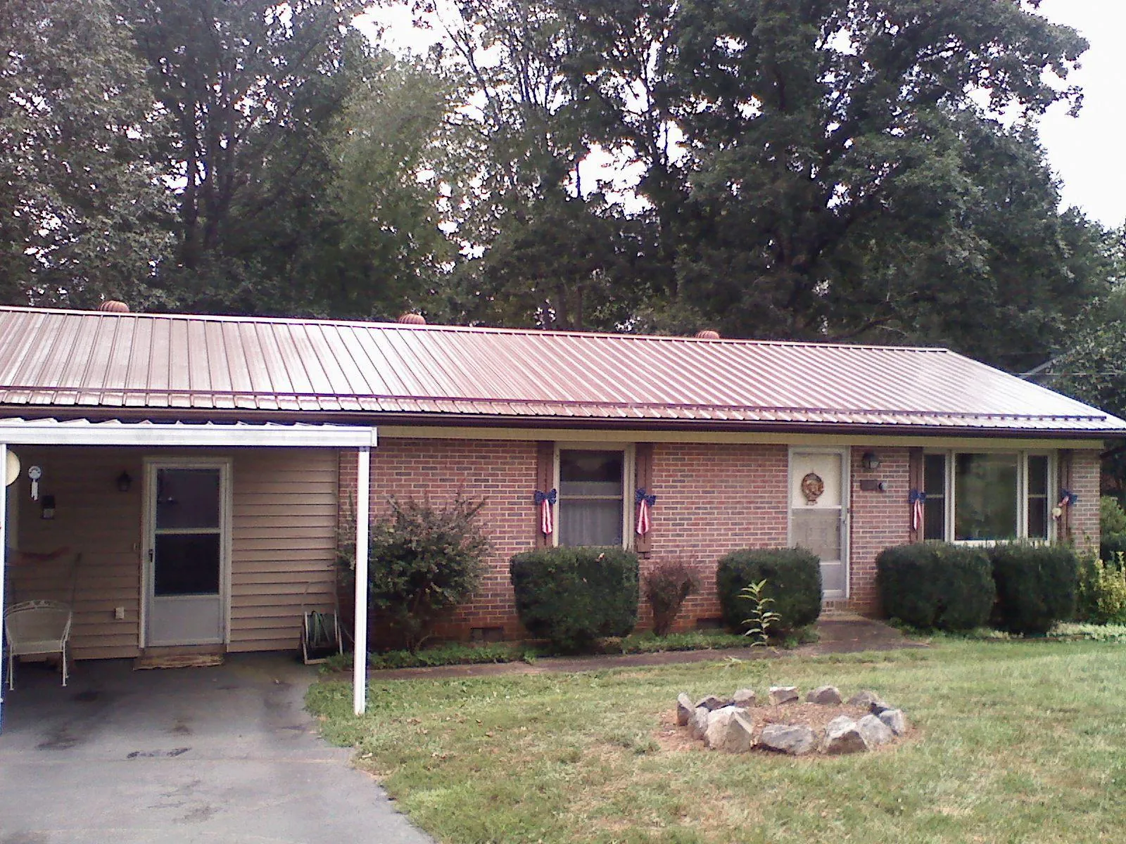 Bronze metal roof and carport on a brick ranch home — Roof Repair work by our crew in Charlotte Court House
